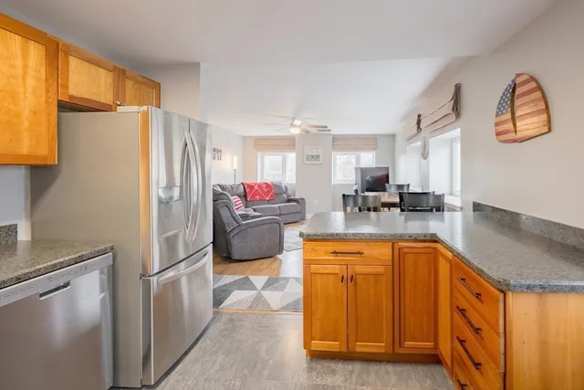 a kitchen with stainless steel appliances granite countertop a refrigerator a sink and a stove