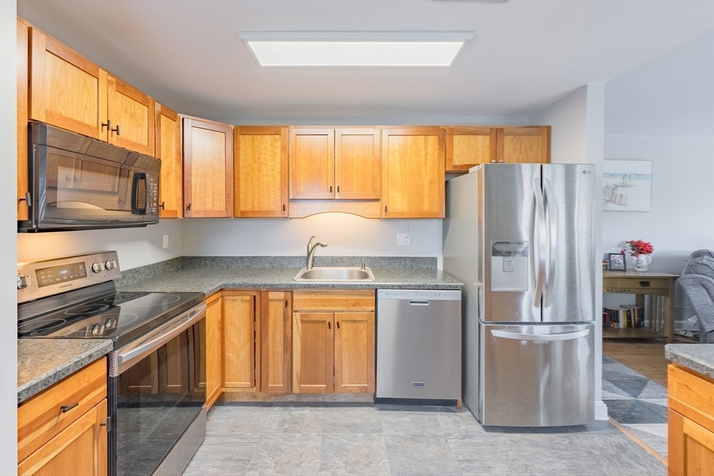 45 Main Street, Unit 38 Wareham, MA 02571 - Photo 14 of 30 a kitchen with stainless steel appliances granite countertop a refrigerator a stove a sink and a microwave