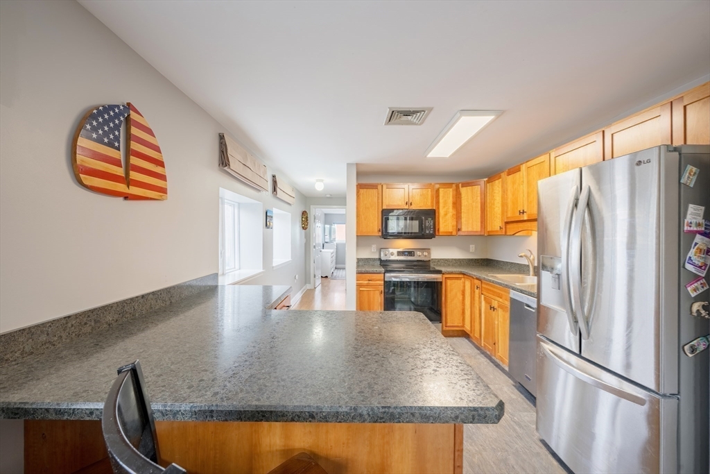 45 Main Street, Unit 38 Wareham, MA 02571 - Photo 15 of 30 a kitchen with stainless steel appliances granite countertop a refrigerator a stove and a sink with cabinets