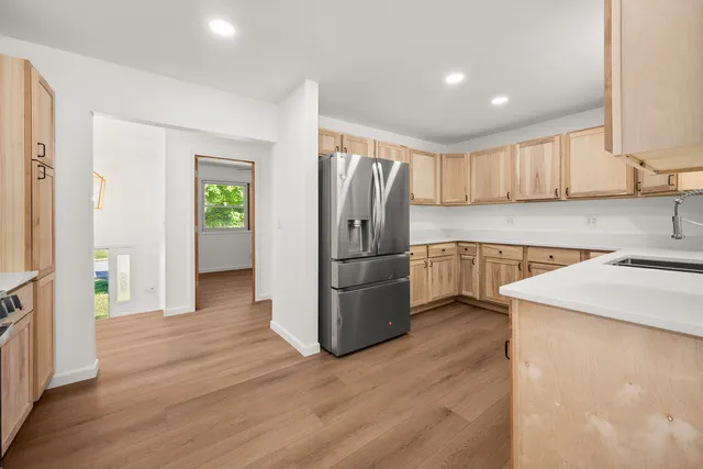 a kitchen with stainless steel appliances granite countertop a refrigerator and a stove top oven