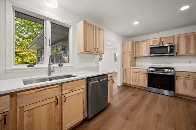 a kitchen with stainless steel appliances white cabinets a sink and a stove