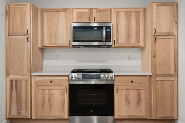 a kitchen with stainless steel appliances wooden cabinets and a stove top oven
