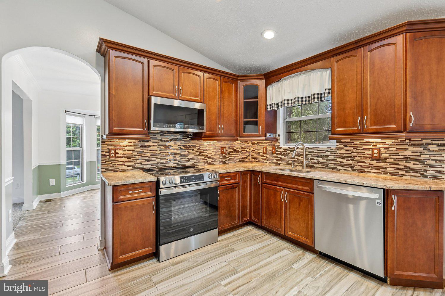 15764 Beau Ridge Drive Woodbridge, VA 22193 - Photo 10 of 58 a kitchen with stainless steel appliances granite countertop wooden cabinets a sink and dishwasher a stove with wooden floor