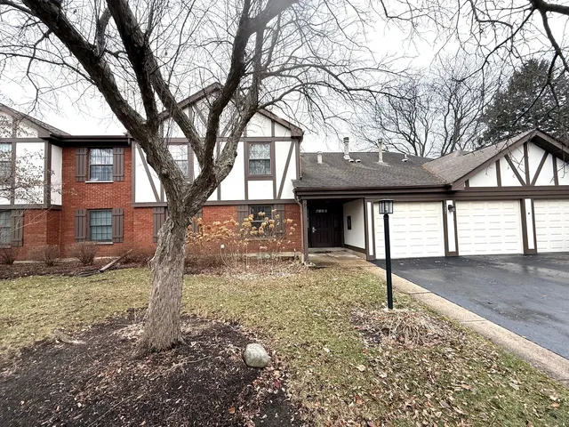a view of a house with a tree in the yard