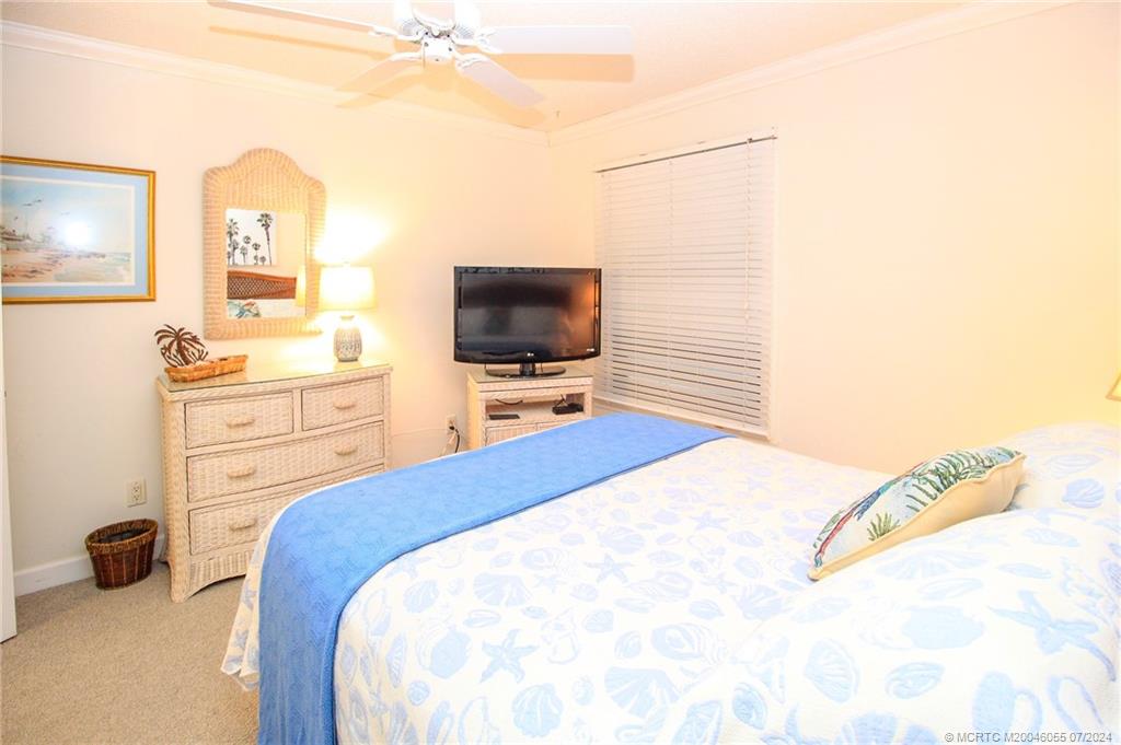 350 Northeast Edgewater Drive, Unit 202 Stuart, FL 34996 - Photo 19 of 28 a bedroom with a bed and a flat screen tv