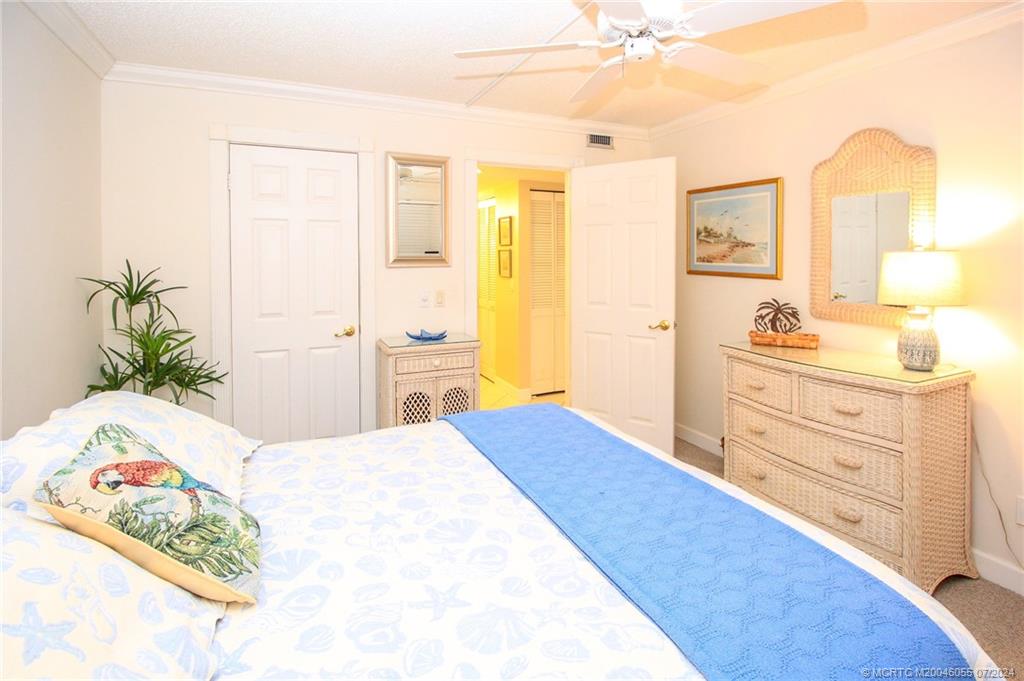 350 Northeast Edgewater Drive, Unit 202 Stuart, FL 34996 - Photo 20 of 28 a bedroom with a bed and a dresser in it