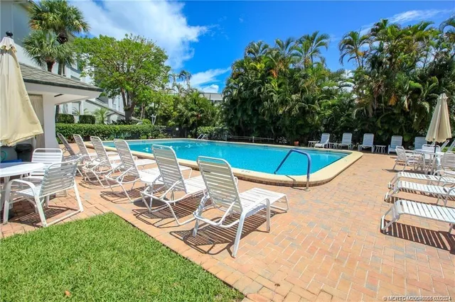 a view of a chairs and table in patio with a swimming pool