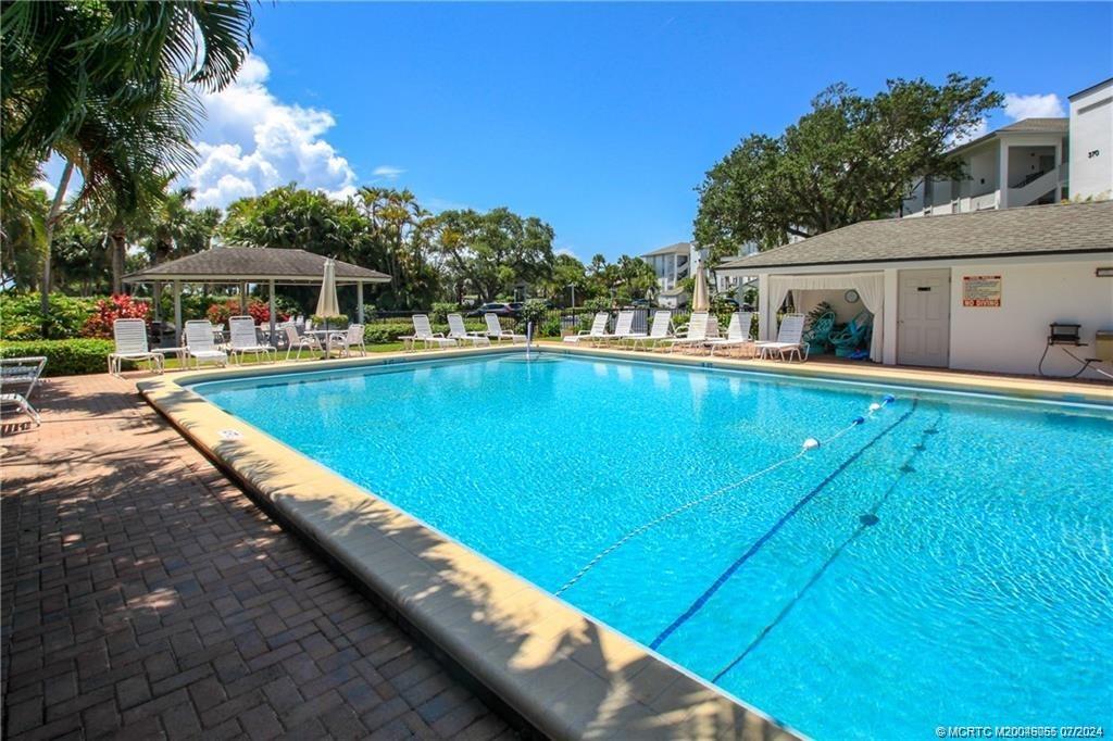 350 Northeast Edgewater Drive, Unit 202 Stuart, FL 34996 - Photo 25 of 28 a view of a house with pool and chairs
