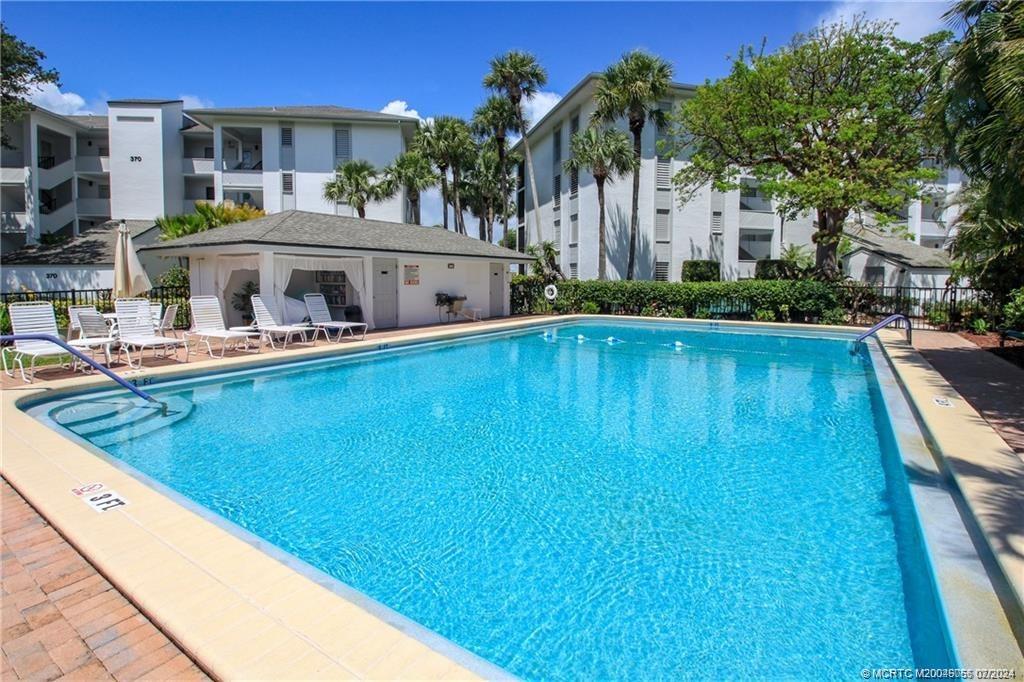 350 Northeast Edgewater Drive, Unit 202 Stuart, FL 34996 - Photo 27 of 28 a front view of house with yard swimming pool and outdoor seating
