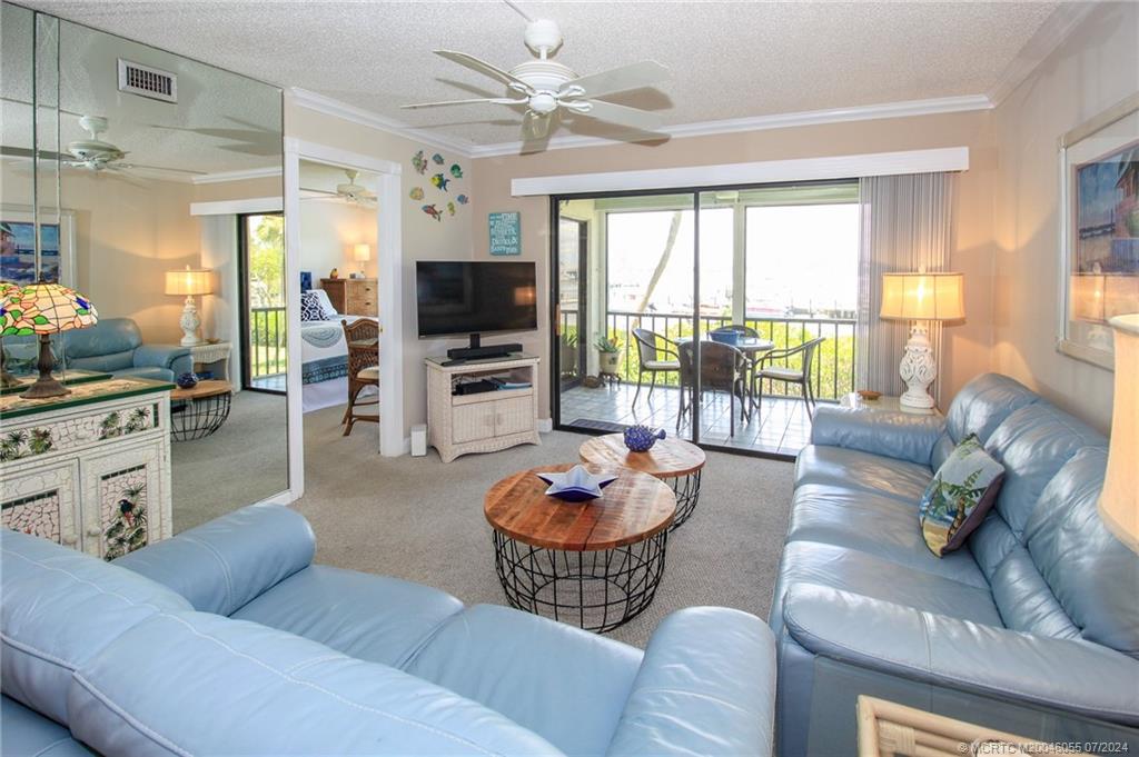 350 Northeast Edgewater Drive, Unit 202 Stuart, FL 34996 - Photo 6 of 28 a living room with furniture and a large window