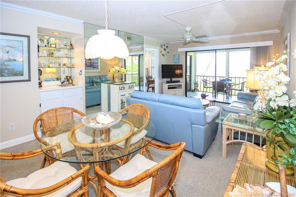 350 Northeast Edgewater Drive, Unit 202 Stuart, FL 34996 - Photo 7 of 28 a view of a dining room with furniture wooden floor and chandelier