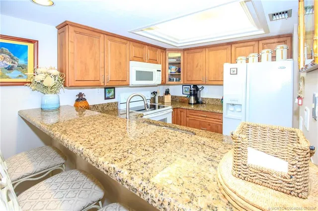a kitchen with granite countertop a sink stove and cabinets