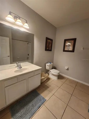 a spacious bathroom with a toilet sink and mirror