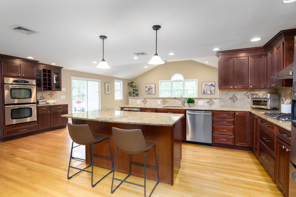 6 Old Meadow Lane Canton, MA 02021 - Photo 2 of 35 a kitchen with stainless steel appliances granite countertop a sink a stove a refrigerator cabinets and chairs