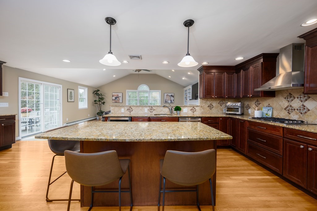 6 Old Meadow Lane Canton, MA 02021 - Photo 25 of 35 a kitchen with stainless steel appliances granite countertop a kitchen island a stove a table and chairs in it