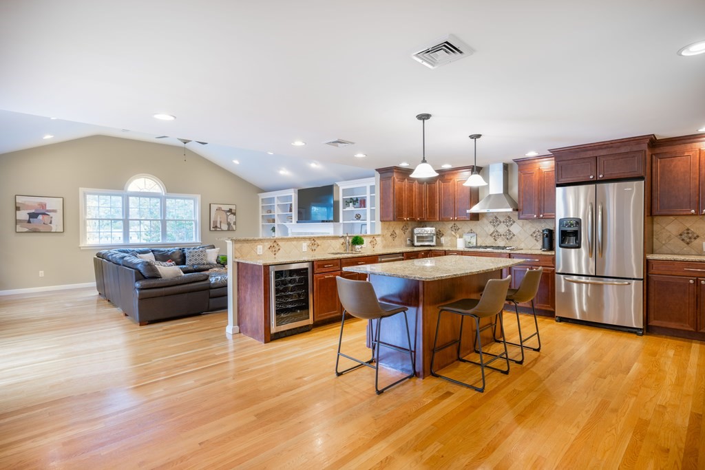6 Old Meadow Lane Canton, MA 02021 - Photo 3 of 35 a kitchen with stainless steel appliances kitchen island granite countertop a table chairs and a refrigerator