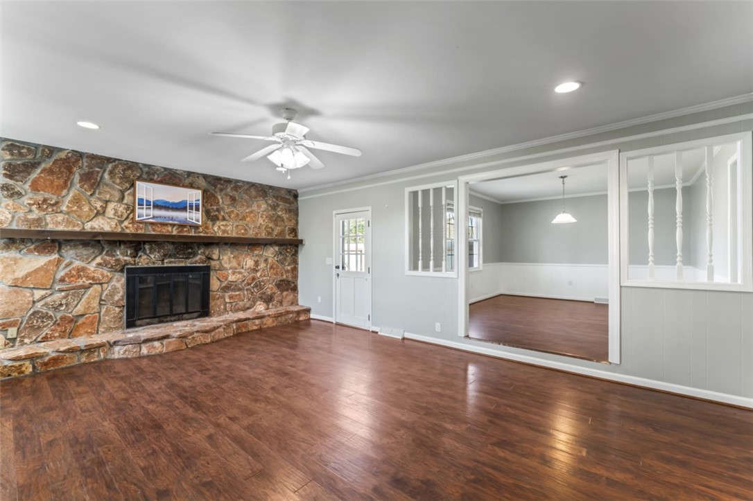 304 Stonehaven Drive Anderson, SC 29625 - Photo 3 of 19 A spacious living room welcomes with a natural stone fireplace and rich hardwood flooring throughout.