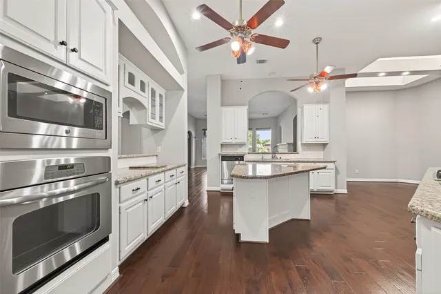 a kitchen with stainless steel appliances a chandelier and wooden cabinets