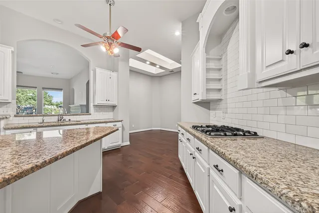 a kitchen with stainless steel appliances granite countertop a sink a stove oven a counter space and cabinets