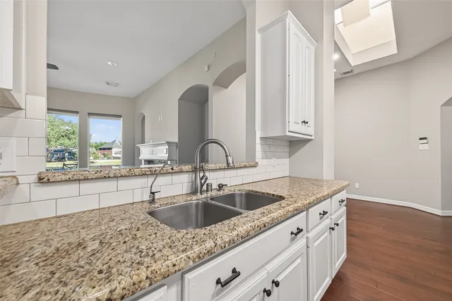 a kitchen with granite countertop a sink and a stove