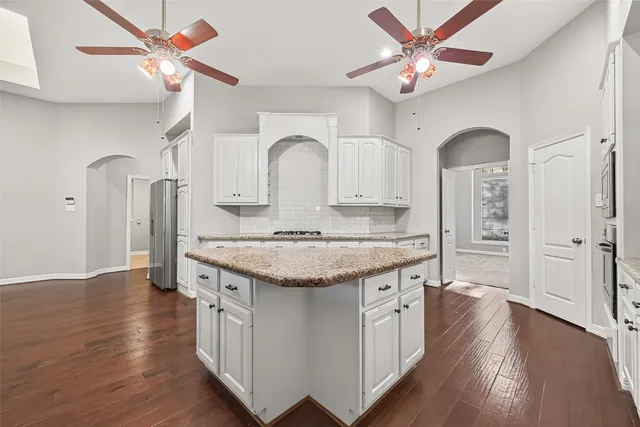 a kitchen with granite countertop a sink cabinets and wooden floor