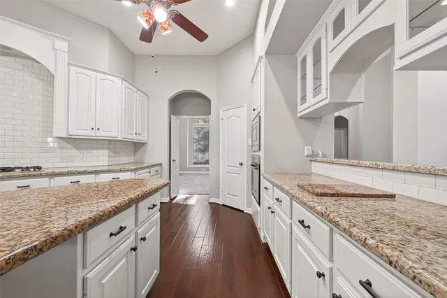 a large kitchen with granite countertop a lot of counter space and wooden floor