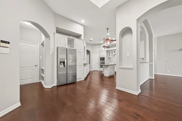 a view of a kitchen with a refrigerator and wooden floor
