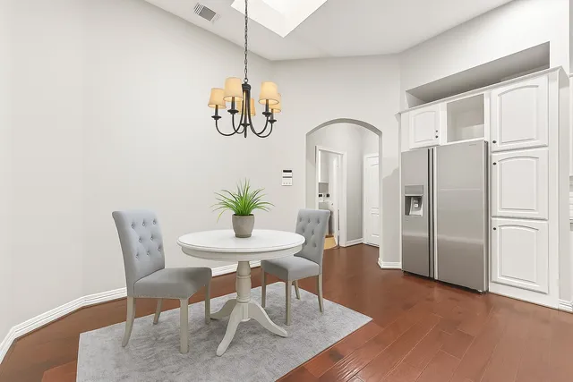 a view of a dining room with furniture a chandelier and wooden floor