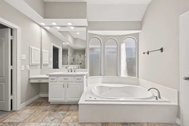 a bathroom with a tub sink and mirror