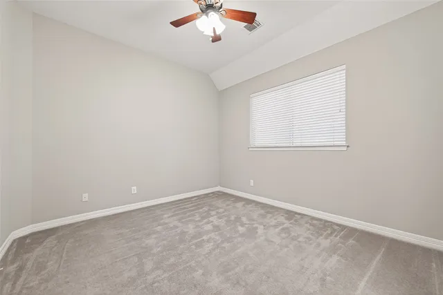 an empty room with a ceiling fan and a window
