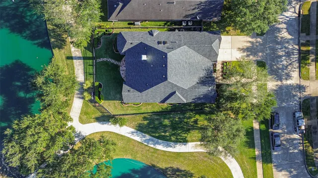 an aerial view of a house with a garden and lake view