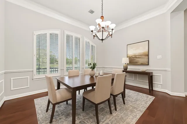 a view of a dining room with furniture a chandelier and wooden floor