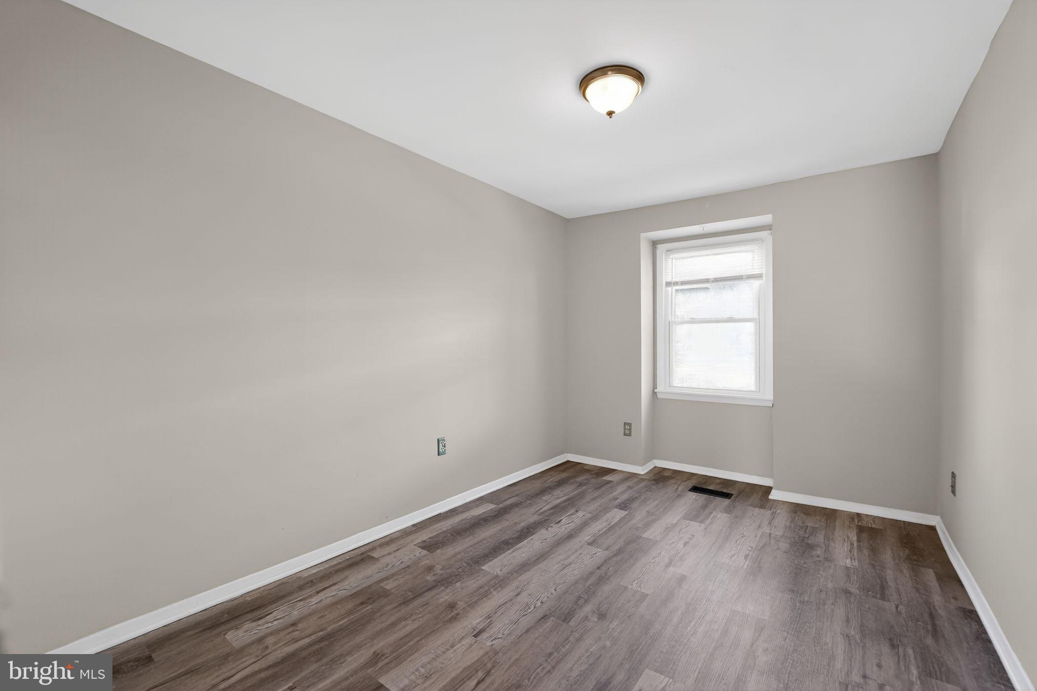 14 Pickens Court Baltimore, MD 21236 - Photo 15 of 30 an empty room with wooden floor and windows