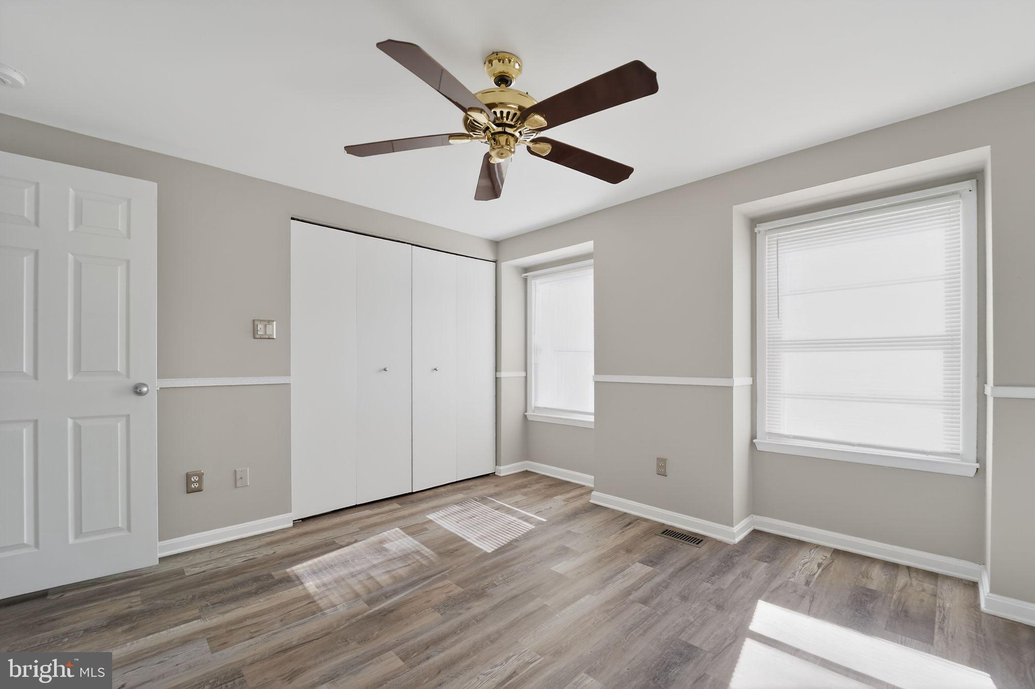 14 Pickens Court Baltimore, MD 21236 - Photo 20 of 30 an empty room with wooden floor ceiling fan and windows