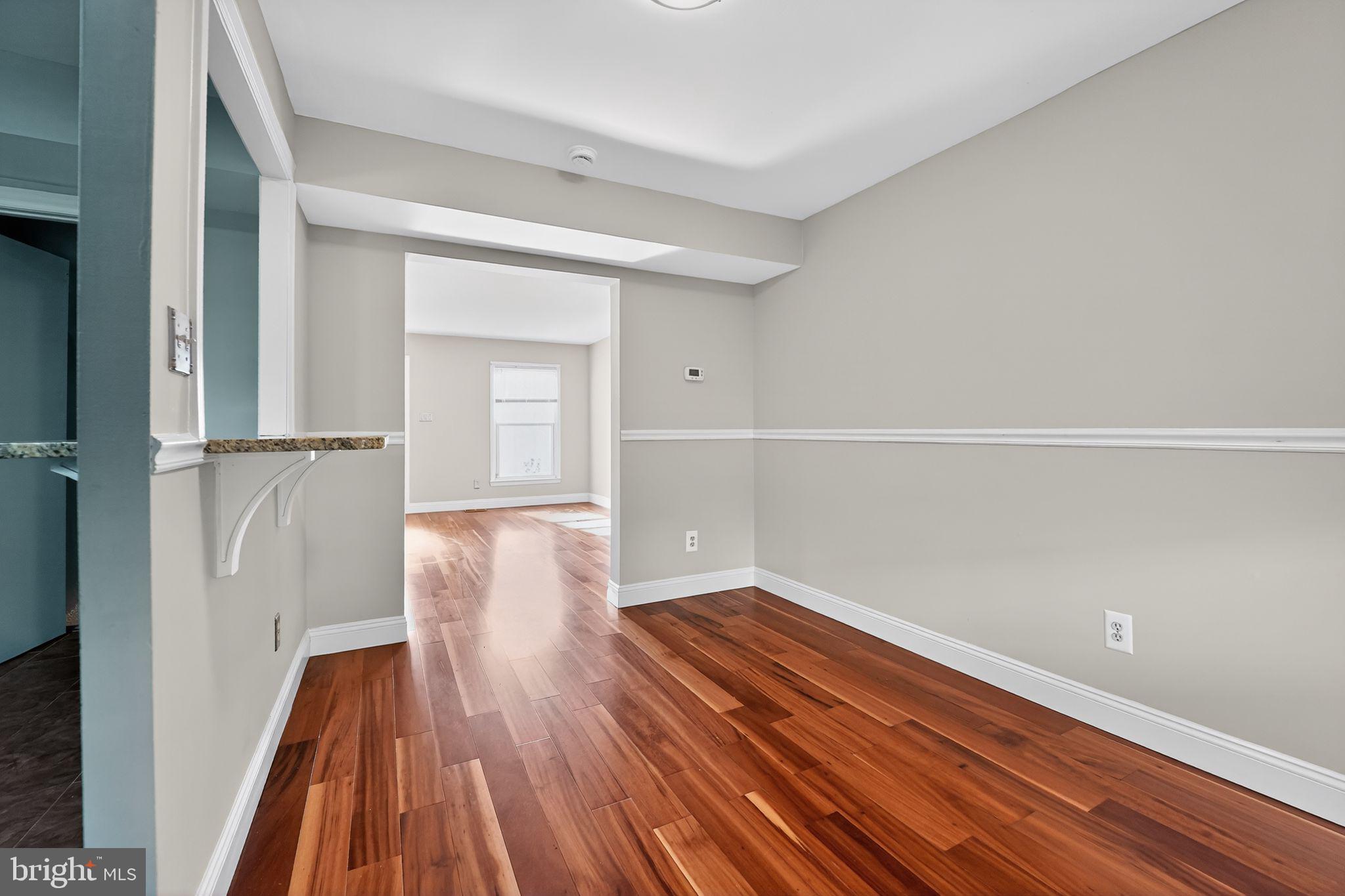 14 Pickens Court Baltimore, MD 21236 - Photo 6 of 30 a view of an empty room with wooden floor and a window