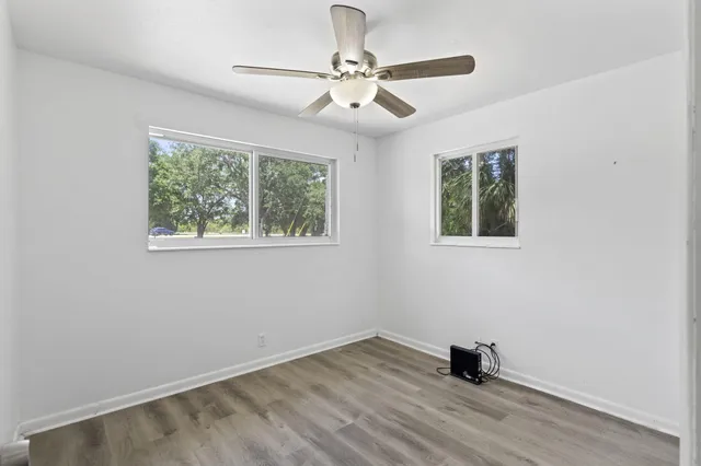 a view of a livingroom with wooden floor and a ceiling fan