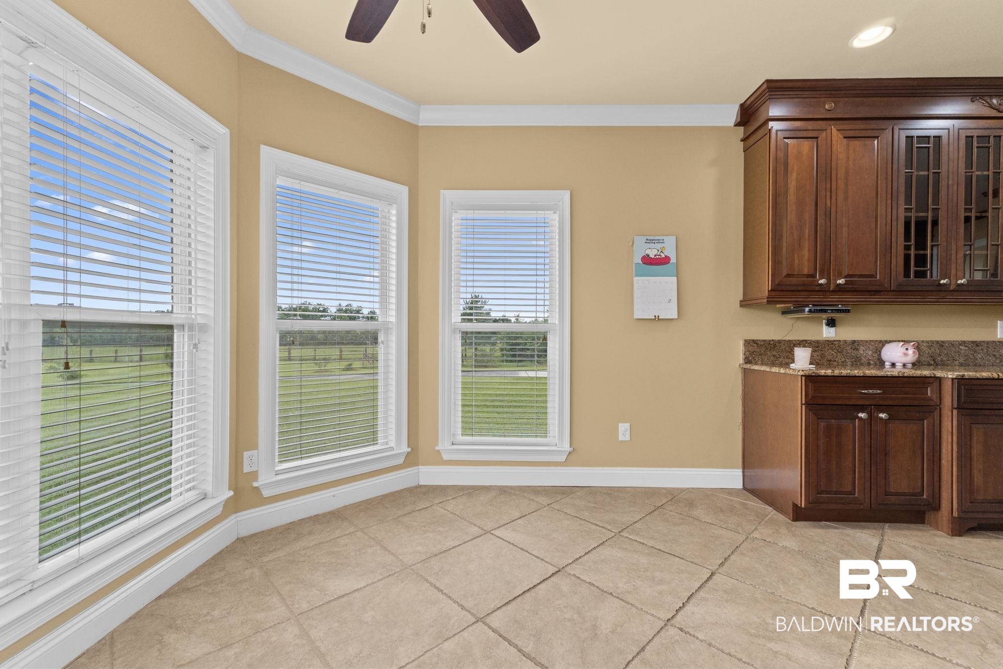 9790 Stucki Road Elberta, AL 36530 - Photo 40 of 72 Kitchen featuring ceiling fan, light stone countertops, baseboards, crown molding, and light tile patterned floors