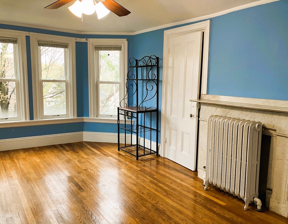 66 Maple Street, Unit 3 Boston, MA 02136 - Photo 3 of 14 a view of an empty room with window and wooden floor