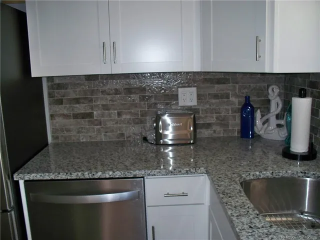 a kitchen with stainless steel appliances granite countertop a sink stove and microwave