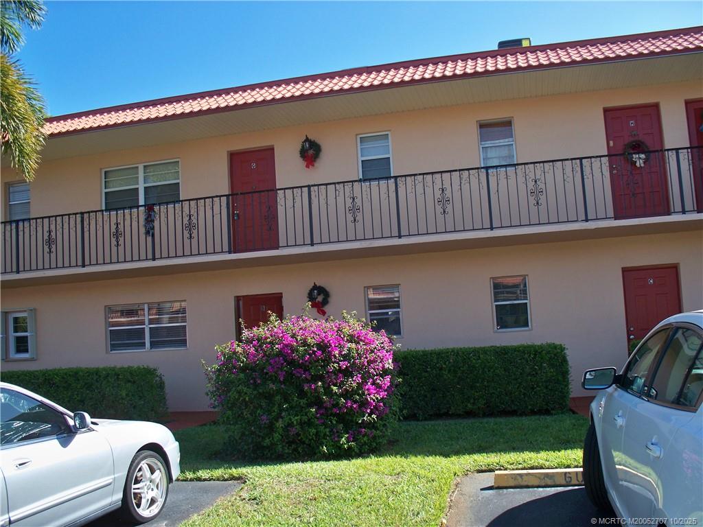 1939 Southwest Palm City Road, Unit G Stuart, FL 34994 - Photo 2 of 34 a front view of a house with a yard
