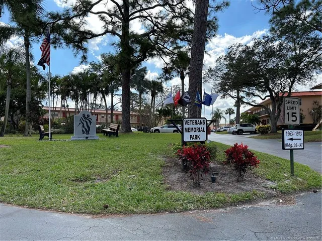 a front view of residential houses with yard and trees in the background