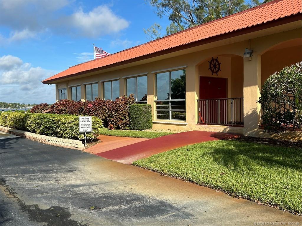1939 Southwest Palm City Road, Unit G Stuart, FL 34994 - Photo 29 of 34 a front view of a house with a yard and garage