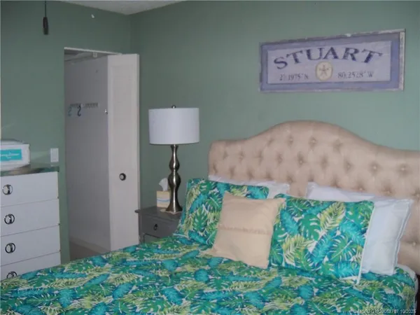 a bed room with a bed and a painting on the wall