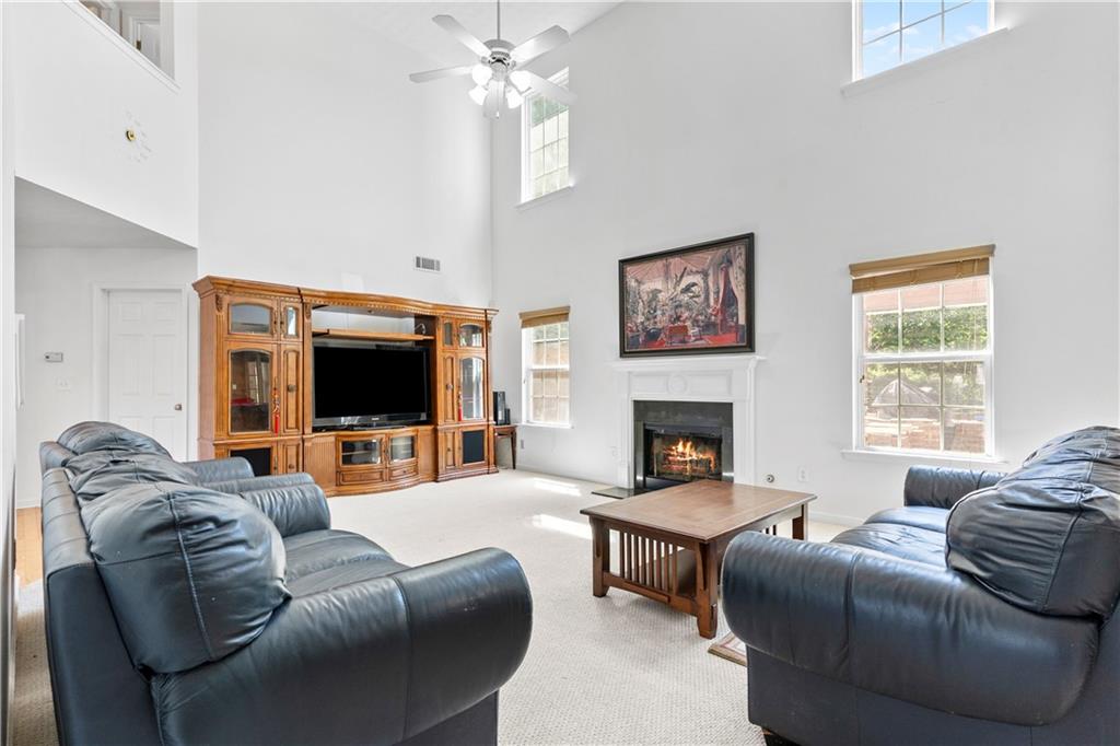 665 Roxford Lane Northeast Buford, GA 30518 - Photo 3 of 19 a living room with furniture a flat screen tv and a fireplace