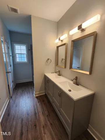 a bathroom with a double vanity sink and mirror