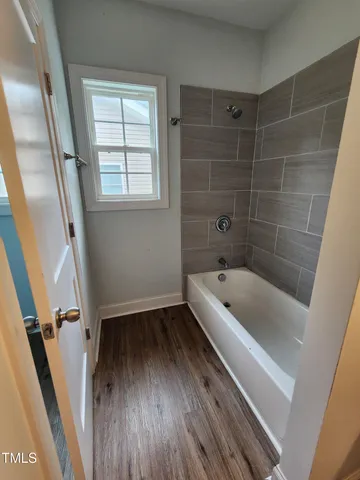 a bathroom with a tub a sink and a window