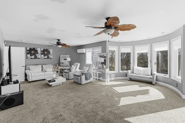 a living room with furniture a large window and a chandelier