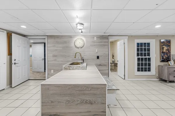 a living room with furniture a flat screen tv and a floor to ceiling window