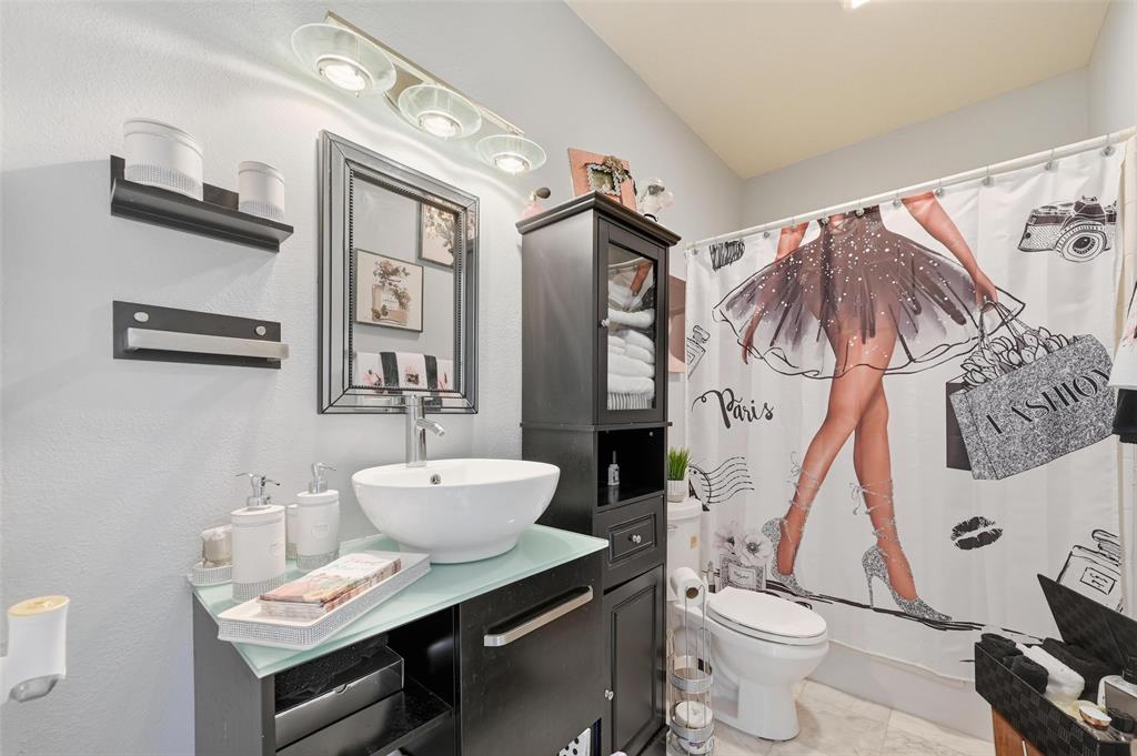 1904 Signal Ridge Place Rockwall, TX 75032 - Photo 21 of 23 Bathroom with vanity, shower / bath combo with shower curtain, and a textured wall