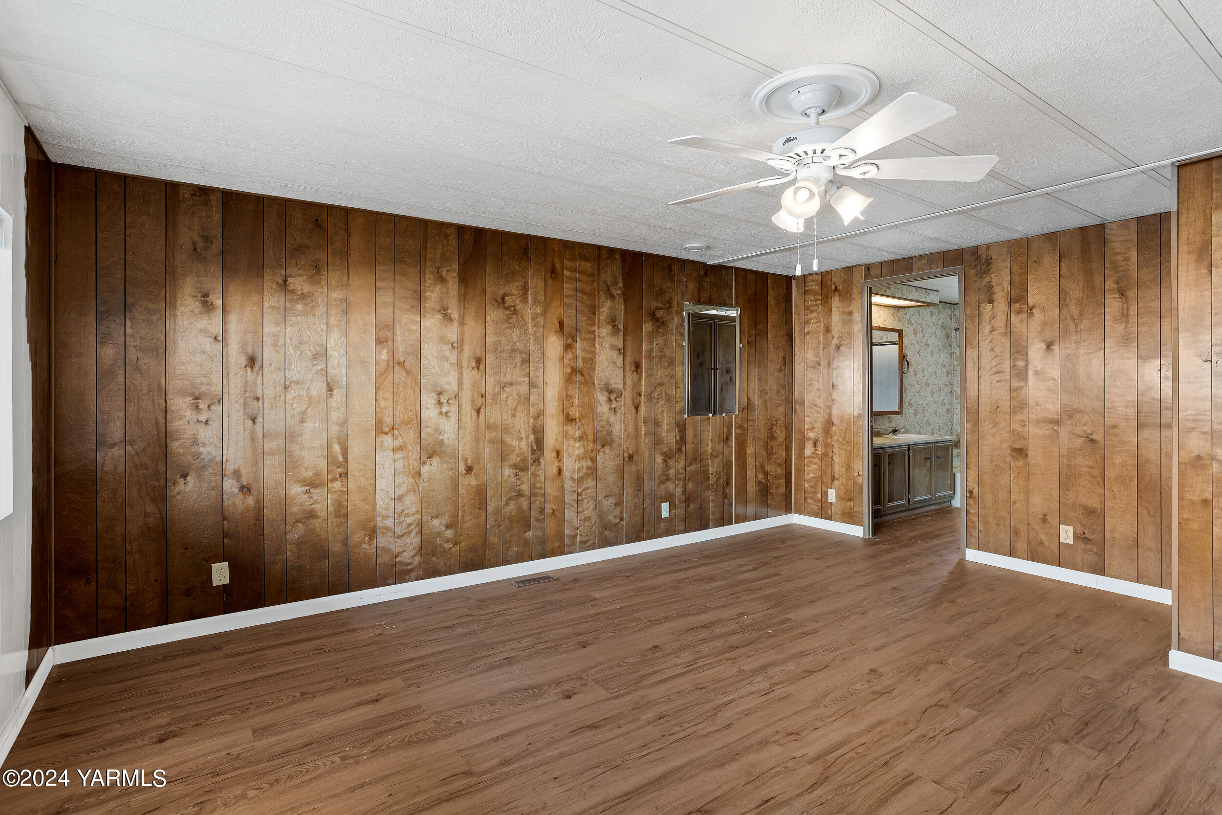 3701 Gun Club Road, Unit 28 Yakima, WA 98901 - Photo 13 of 28 a view of an empty room with wooden floor and a chandelier fan